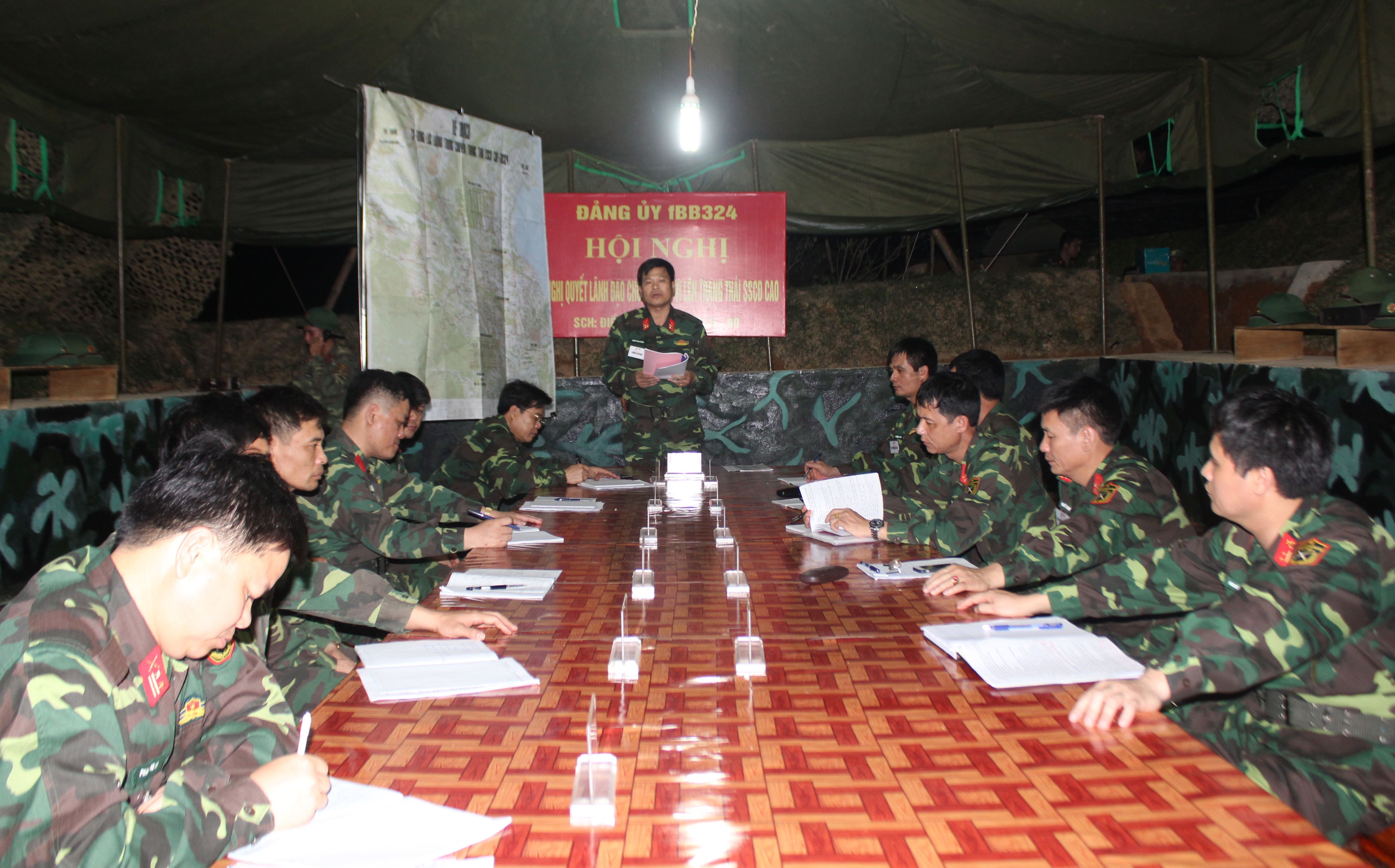 Đồng chí Đại tá Trịnh Văn Hùng - Bí thư Đảng ủy, Chính ủy Sư đoàn chủ trì buổi sinh hoạt Hội nghị ra Nghị quyết chuyển trạng thái lên cao tại khu sơ tán bí mật. Ảnh: Hà Hữu Tân