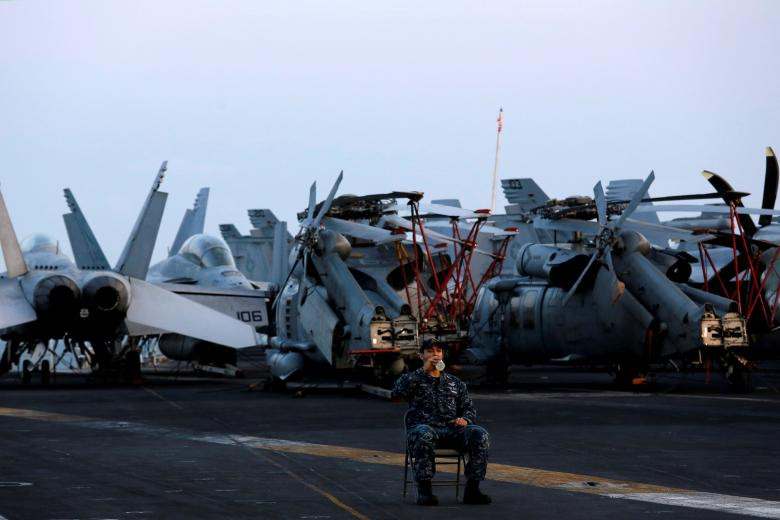 Một thủy thủ uống nước, trong khi ông giữ gìn máy bay, trên chiếc tàu sân bay Hải quân Hoa Kỳ, USS Carl Vinson, sau khi nó đậu tại cảng Đà Nẵng, Việt Nam, ngày 5 tháng 3 năm 2018.