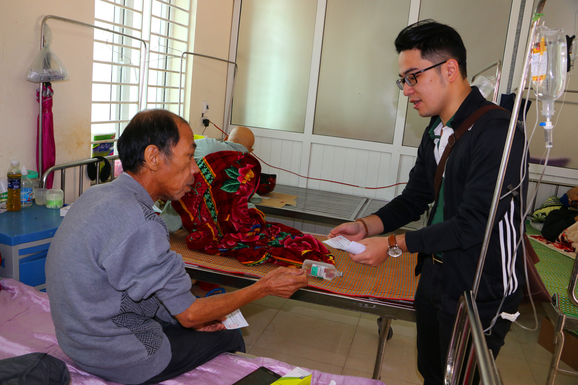 Các đoàn viên thanh niên chi đoàn Vietcombank Nghệ An đến tận giường bệnh để trao phiếu hẹn phát cháo cho các bệnh nhân. Ảnh: Nguyễn Hải