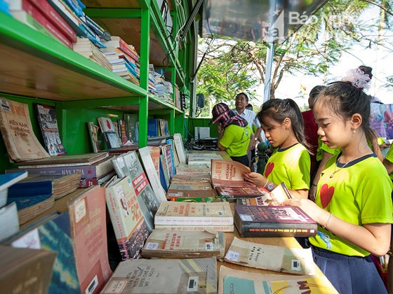 Học sinh say sưa đọc sách tại Ngày sách Việt Nam 2017 được tổ chức tại Quảng trường Hồ Chí Minh. Ảnh tư liệu
