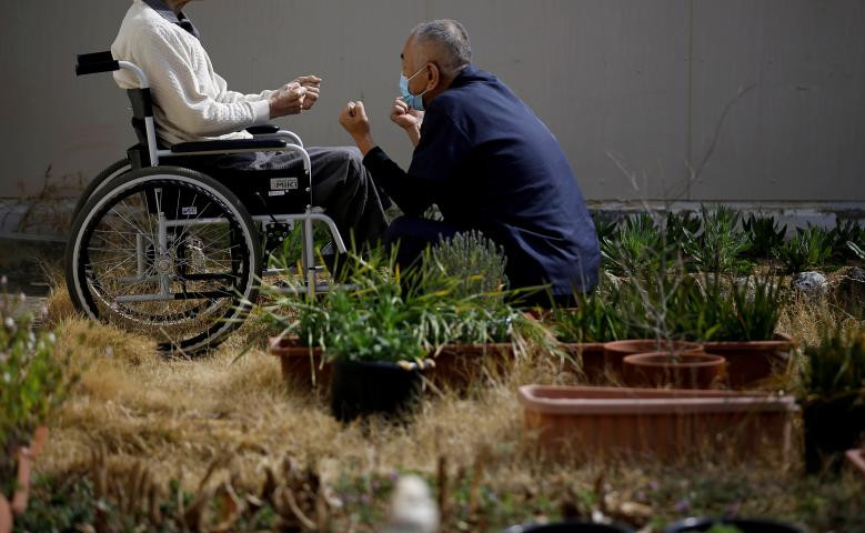 Phạm nhân 92 tuổi ngồi xe lăn, chịu án chung thân tại nhà tù Tokushima vì tội giết người và hãm hiếp, đang tập thể dục với sự trợ giúp của một nhân viên y tế. Ảnh: Reuters.