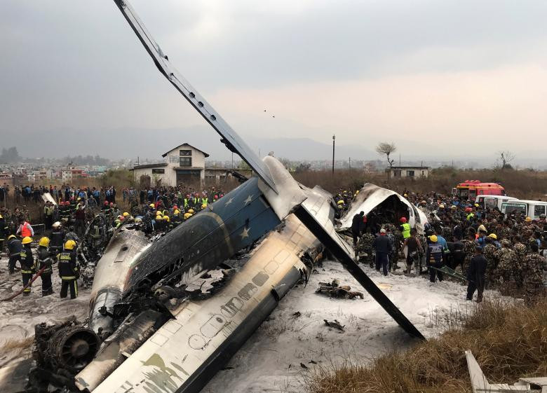 Lực lượng cứu hộ quanh xác máy bay ở sân vận động gần sân bay quốc tế của Kathmandu, Nepal ngày 12/3/2018. Ảnh: Reuters