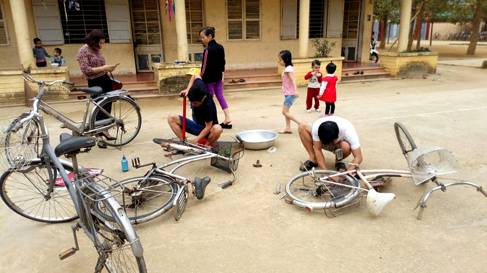 Các thầy giáo sửa chữa xe đạp cũ tặn cho học sinh nghèo. Ảnh: Hùng Cường