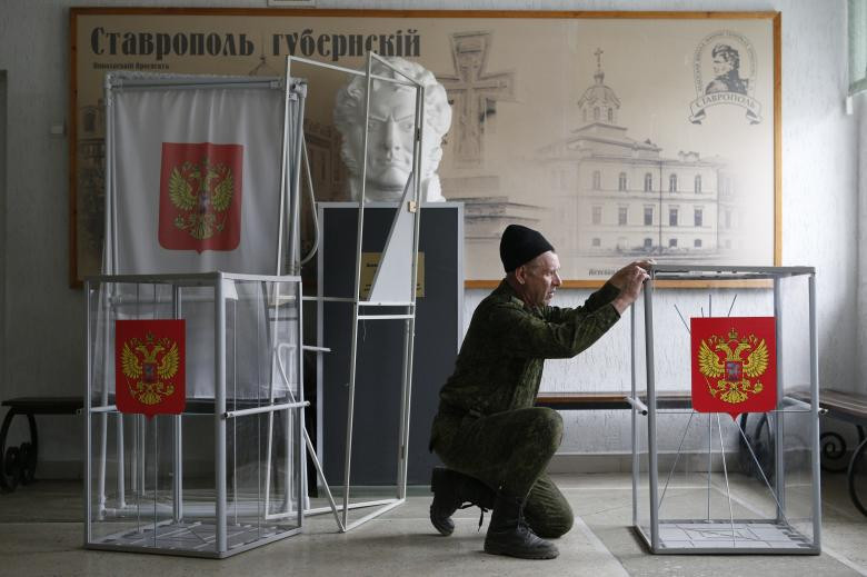 Một nhân viên lắp ráp và đặt các hộp phiếu và các gian hàng bỏ phiếu tại một điểm bỏ phiếu, nằm tại một trường học cadet, trước cuộc bầu cử tổng thống sắp tới tại thành phố Stavropol, Nga ngày 16 tháng 3 năm 2018