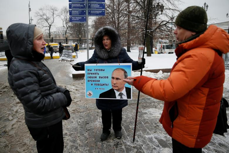 Một nhà hoạt động phân phối các tài liệu bầu cử để hỗ trợ ứng cử viên tổng thống Nga Vladimir Putin ở trung tâm Matxcơva, Nga, ngày 15 tháng 3 năm 2018. Nhãn hiệu viết: 