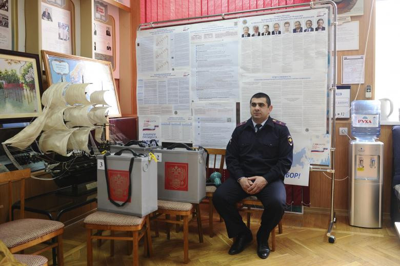 Một cảnh sát viên gần các hộp phiếu tại một phòng bỏ phiếu, đặt tại một trường cao đẳng chuyên chở nước, trong thời gian chuẩn bị cho cuộc bầu cử tổng thống sắp tới ở Rostov on Don, Nga ngày 16 tháng 3 năm 2018.