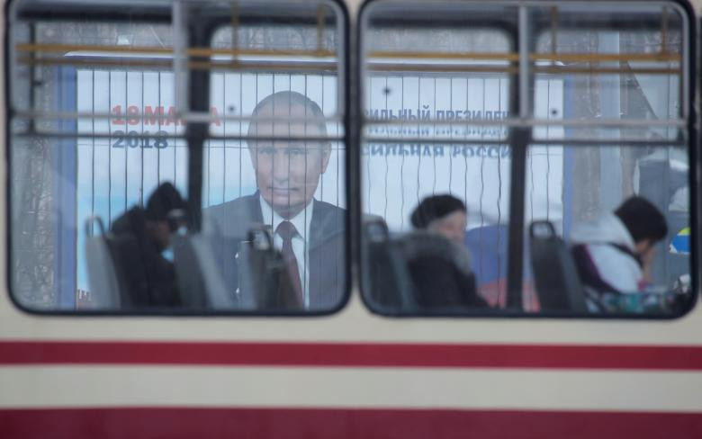 Xe điện chạy ngang qua biển quảng cáo chiến dịch tranh cử của Tổng thống Putin trên đường phố St. Petersburg.