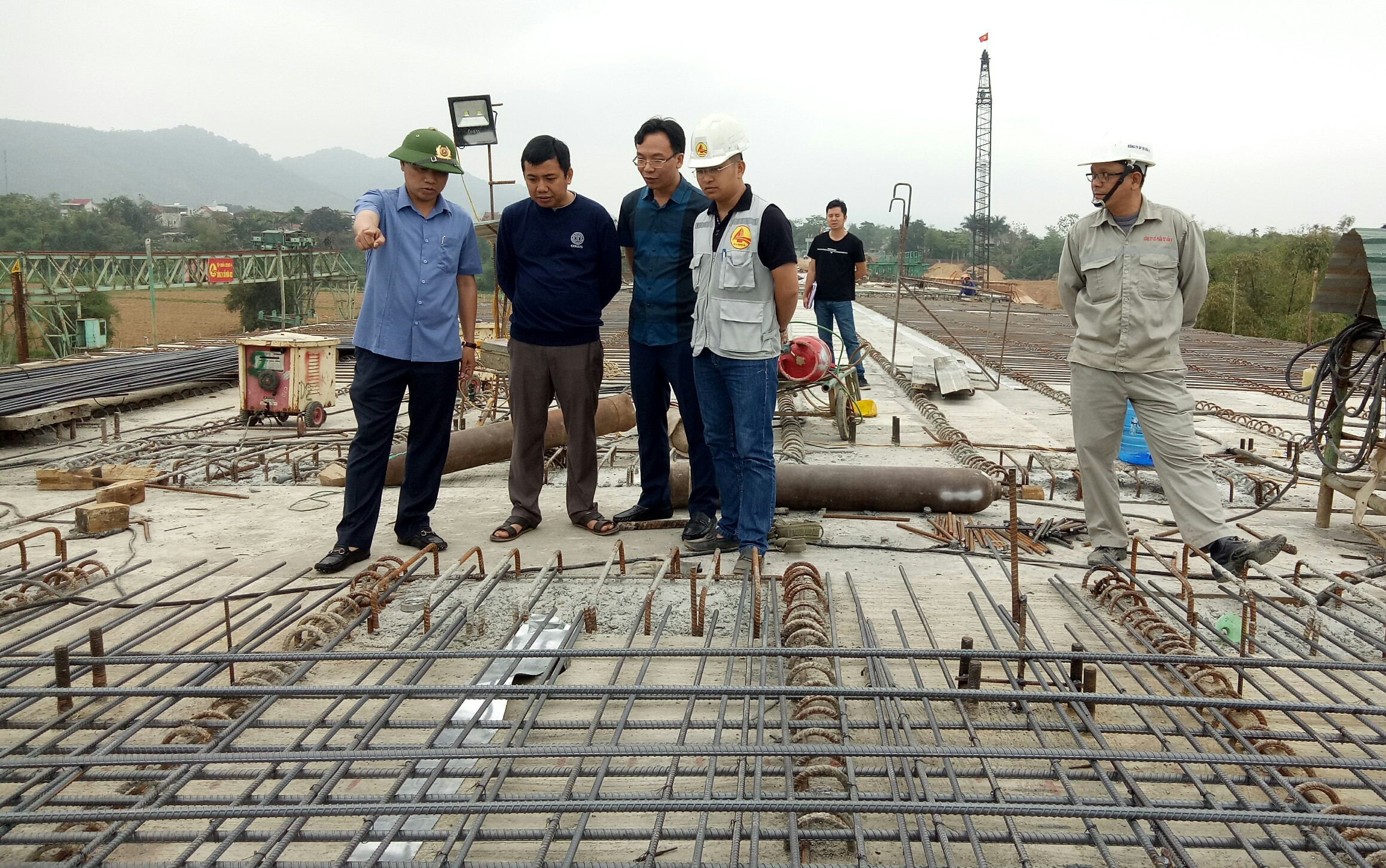 Đồng chí Hoàng Phú Hiền – Chủ tịch UBND thị xã Thái Hòa kiểm tra đôn đốc đơn vị thi công hòa thành dự án cầu Hiếu II. Ảnh: Quang Huy