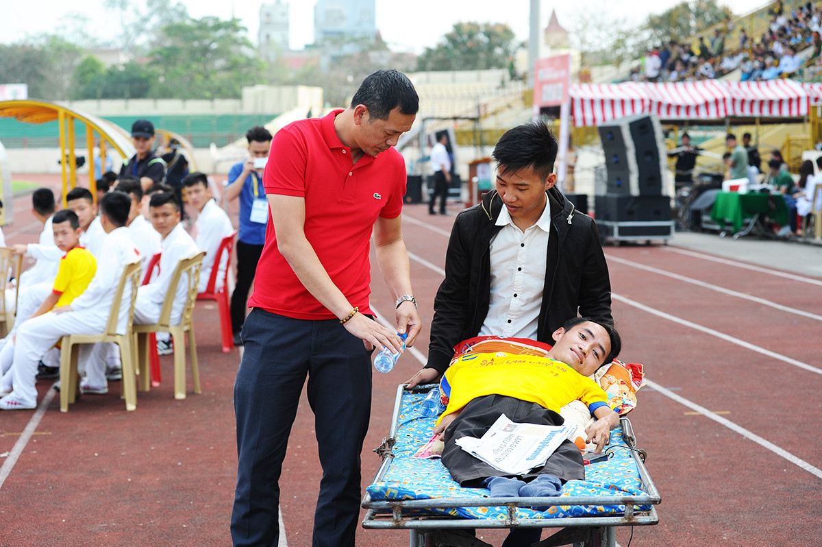 Trong lúc trận đấu chưa diễn ra, HLV Nguyễn Đức Thắng đến thăm hỏi những CĐV khuyết tật đến cổ vũ cho mình và các học trò. Ảnh: Thành Cường