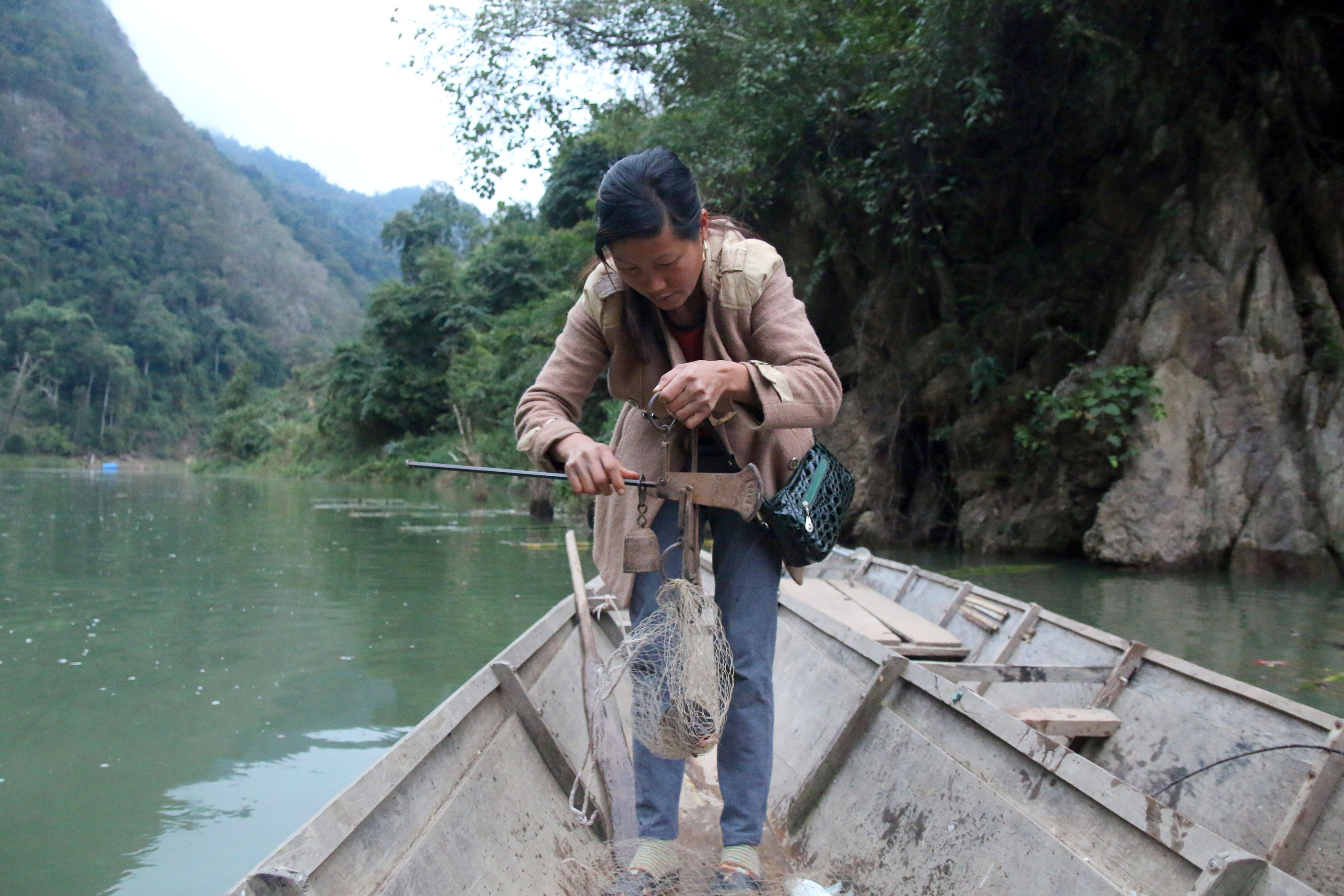 Họ đi qua nhiều khúc sông cân từng mớ cá nhỏ trên sông Nậm Nơn về bán lại kiếm tiền nuôi gia đình. Ảnh: Đào Thọ