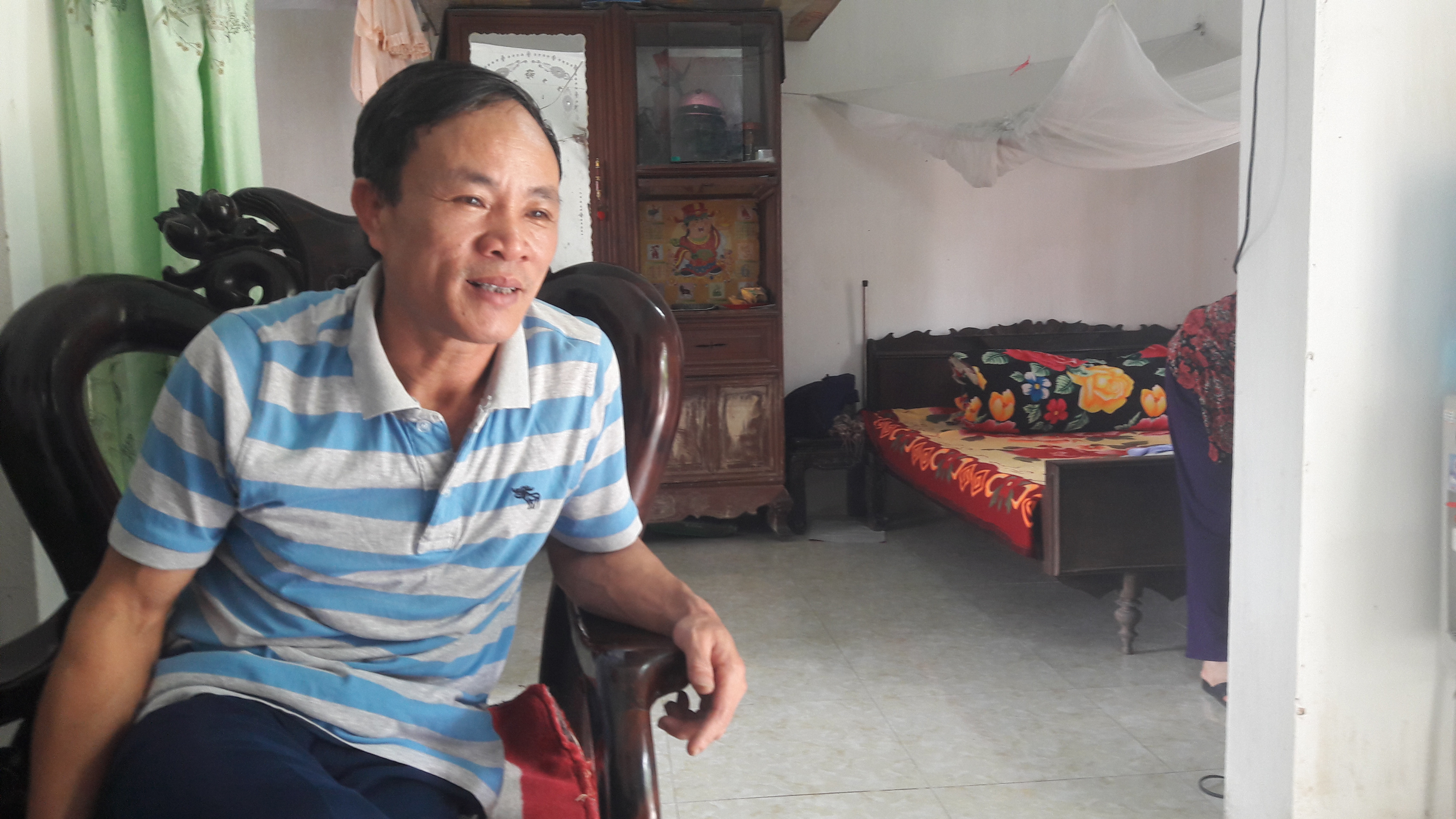 Ông Võ Văn Trung kể về những trận lụt, nước tràn vào nhà đến ngực. Ảnh: Phạm Bằng