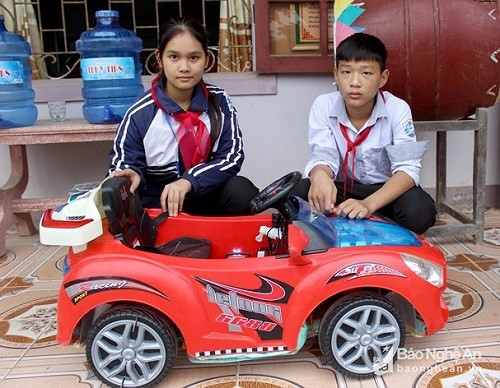 Hai em Nguyễn Thị Thùy Trang và Nguyễn Đức Đô, học sinh lớp 9, Trường THCS Diễn Hải, huyện Diễn Châu bên mô hình phao cứu trợ ô tô bị ngập lụt. 