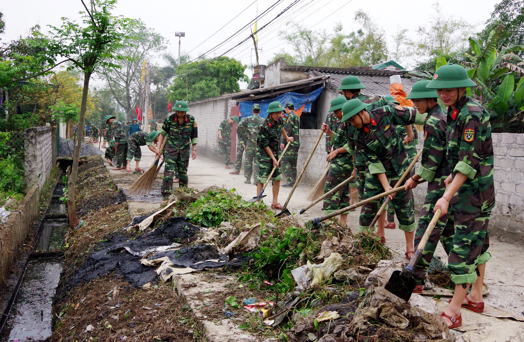 bna_Các đoàn viên, chiến sỹ đang nạo vét hệ thống kênh mương trong khu dân cư xóm 9 xã Nghi Kim, ảnh Phong Quang