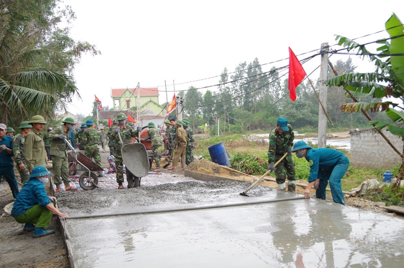 Lực lượng dân quân tự vệ giúp nhân dân xóm Tân Thắng, xã An Hòa, huyện Quỳnh Lưu làm đường giao thông nông thôn mới. Ảnh: Trọng Kiên