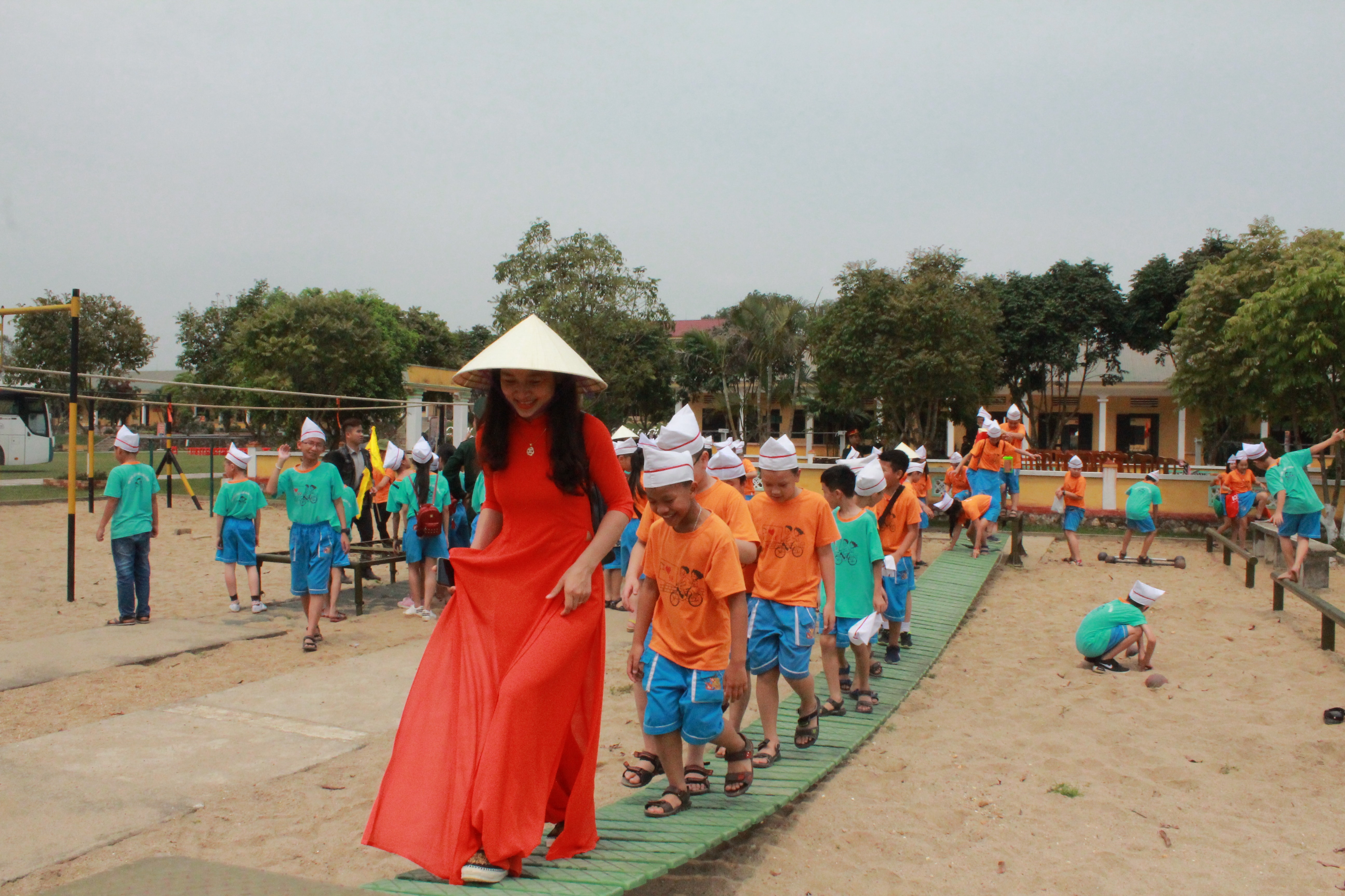 Cô giáo và các em học sinh thích thú được trải nghiệm đi trên cầu độc mộc rèn luyện kỹ năng khéo léo. Ảnh: Tường Hiếu