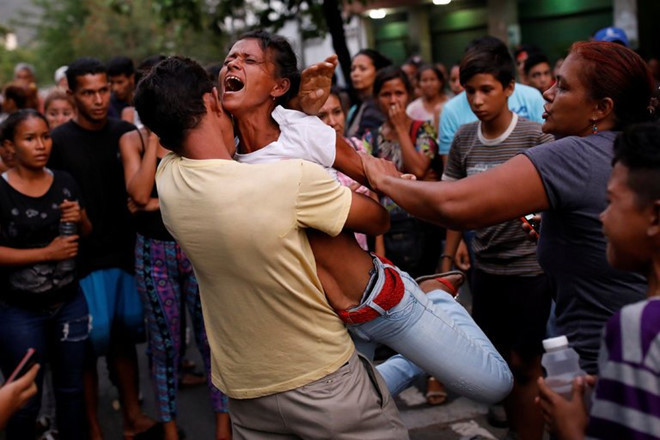 Người nhà của các tù nhân gào khóc trong cuộc xung đột làm 68 người chết. Ảnh: Reuters.