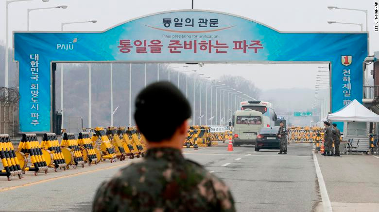 Binh lính Hàn Quốc đứng nhìn đoàn xe chở phái đoàn Triều Tiên đi qua Cầu Thống nhất dẫn tới làng Panmunjom ở Khu vực phi quân sự hôm 29/3. Ảnh: AP