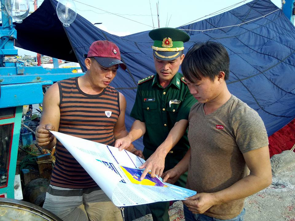 Ngư dân Quỳnh Lưu được cán bộ Đồn biên phòng hưỡng dẫn cách sử dụng bản đồ để khai thác đúng luật biển. Ảnh: Như Thủy