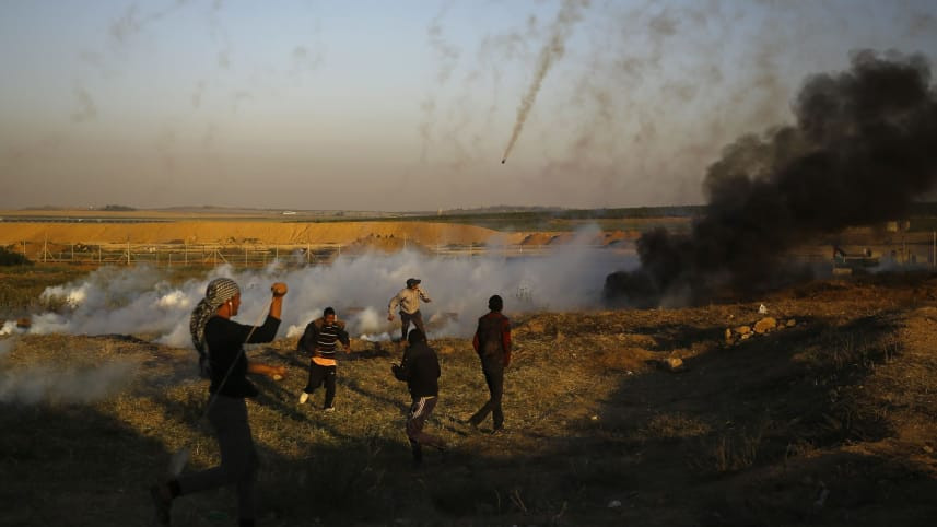 Người biểu tình Palestine chạy trốn khỏi đạn hơi cay của Israel tại phía Đông thành phố Gaza hôm 1-4 (AFP)
