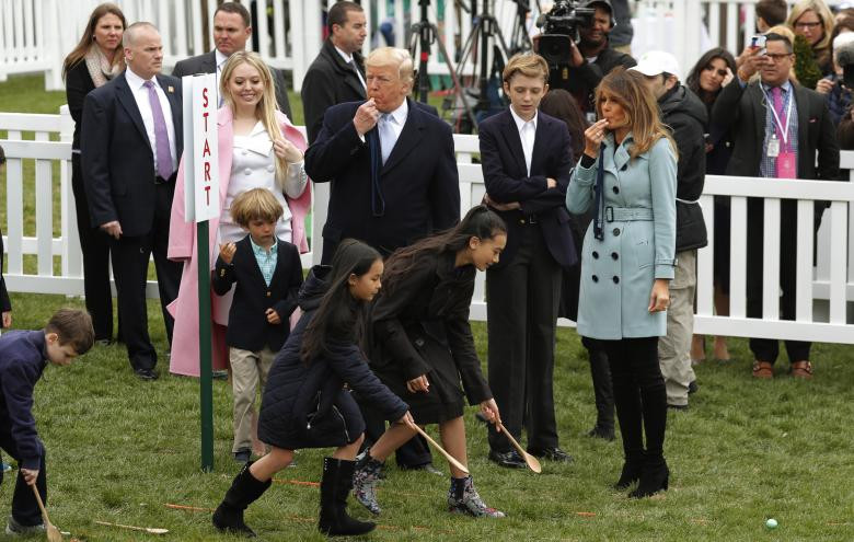 Tổng thống Trump cùng phu nhân thổi còi để bắt đầu cuộc đua lăn trứng dành cho trẻ em. Ảnh: Reuters