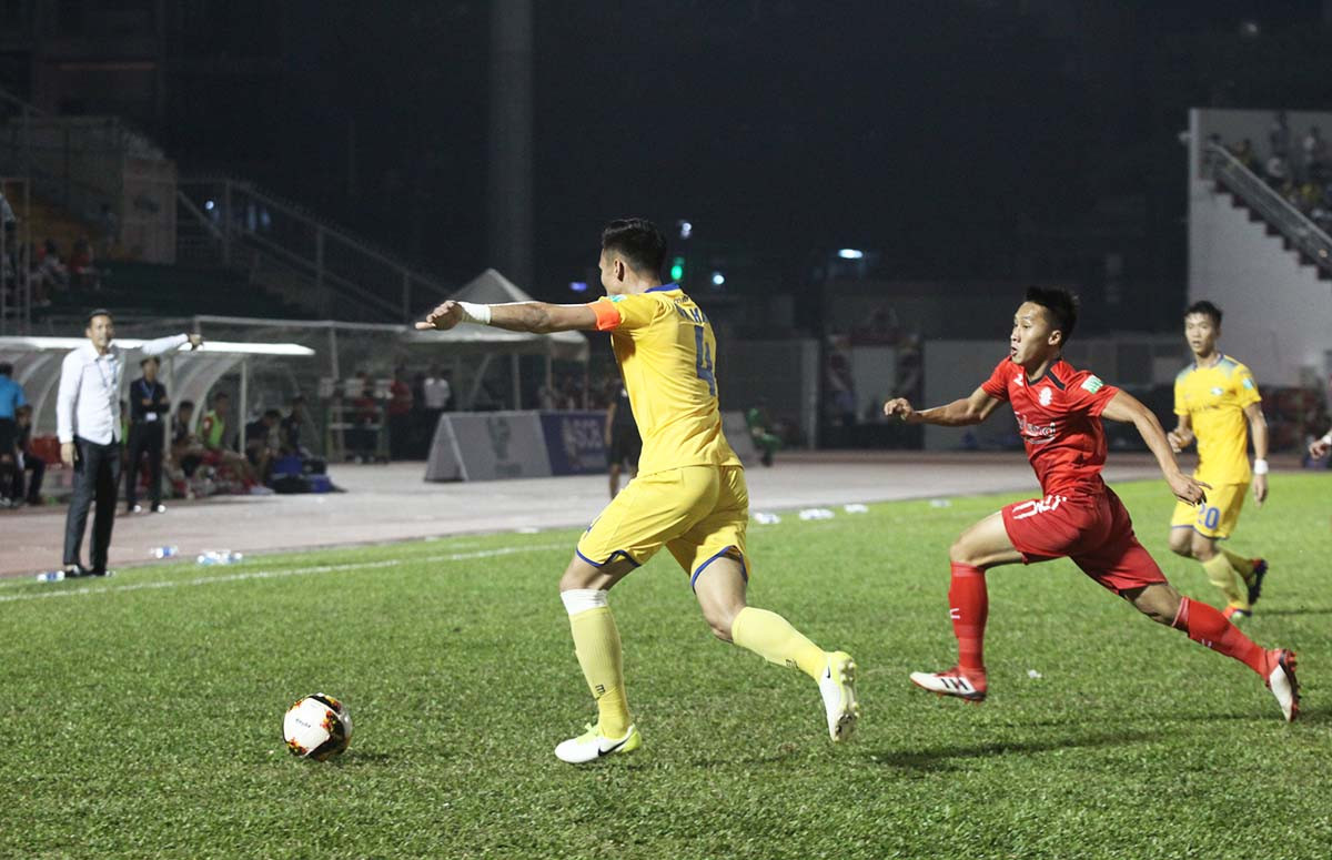 Một pha bóng Quế Ngọc Hải đối đầu với cầu thủ TP Hồ Chí Minh trong thế phải phá bóng lên. Ảnh: Nguyên Hải