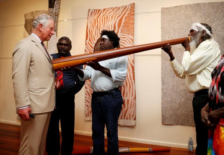 Prince Charles tham gia một cuộc trình diễn didgeridoo trong chuyến thăm Trung tâm Buku-Larrnggay Mulka ở Yirrkala, Lãnh thổ Bắc, Úc.