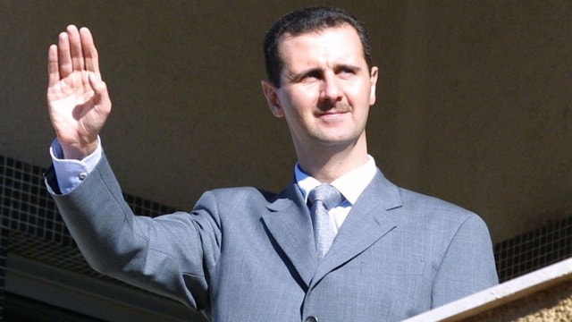 Tổng thống Syria Bashar al-Assad đứng trên ban công dinh tổng thống ở thủ đô Damascus - Ảnh: AFP