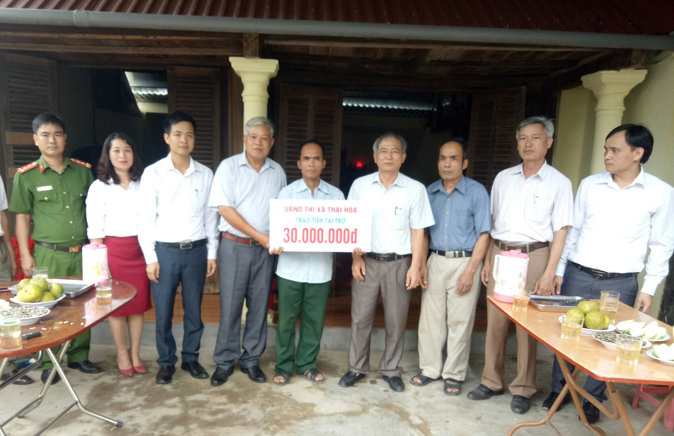 Lãnh đạo thị xã Thái Hòa trao 30 triệu đồng hỗ trợ gia đình ông Hồng sửa nhà. Ảnh : Quang Huy.