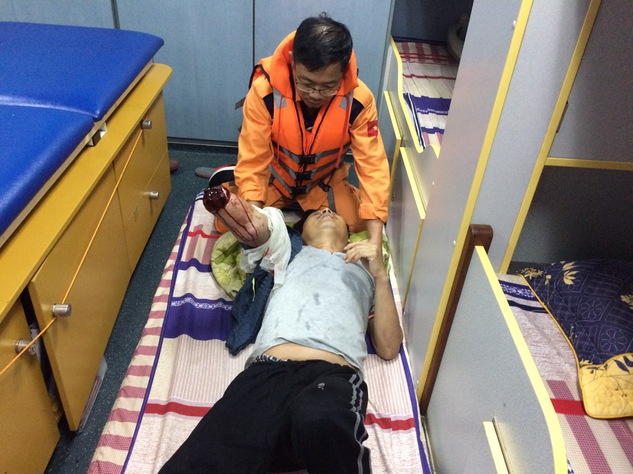 Nhân viên y tế tàu SAR 411  sơ cứu cho thuyền viên bị nạn. Ảnh: Hữu Lương