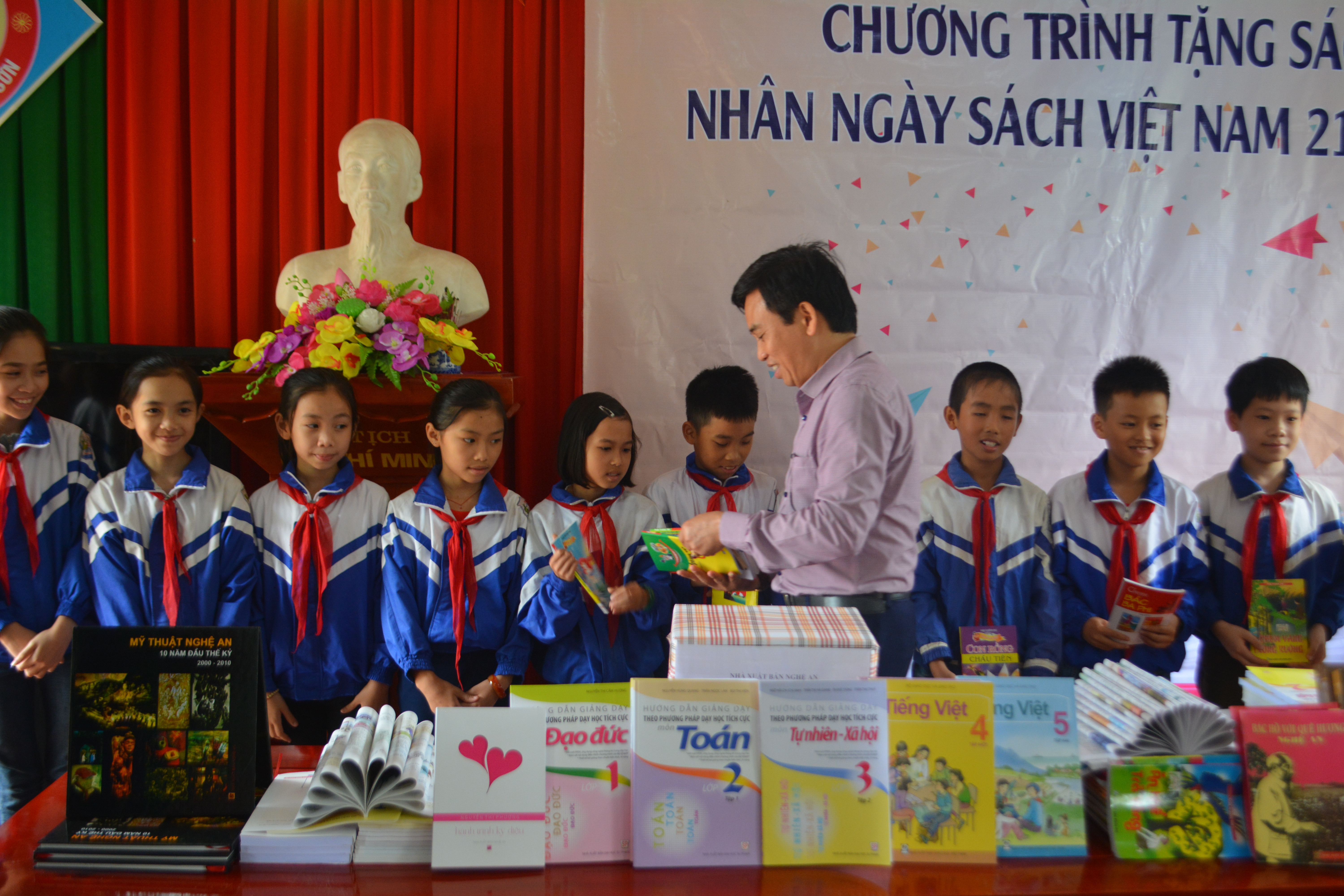 Đồng chí Nguyễn Bá Hảo tặng sách cho học sinh. Ảnh: B.H