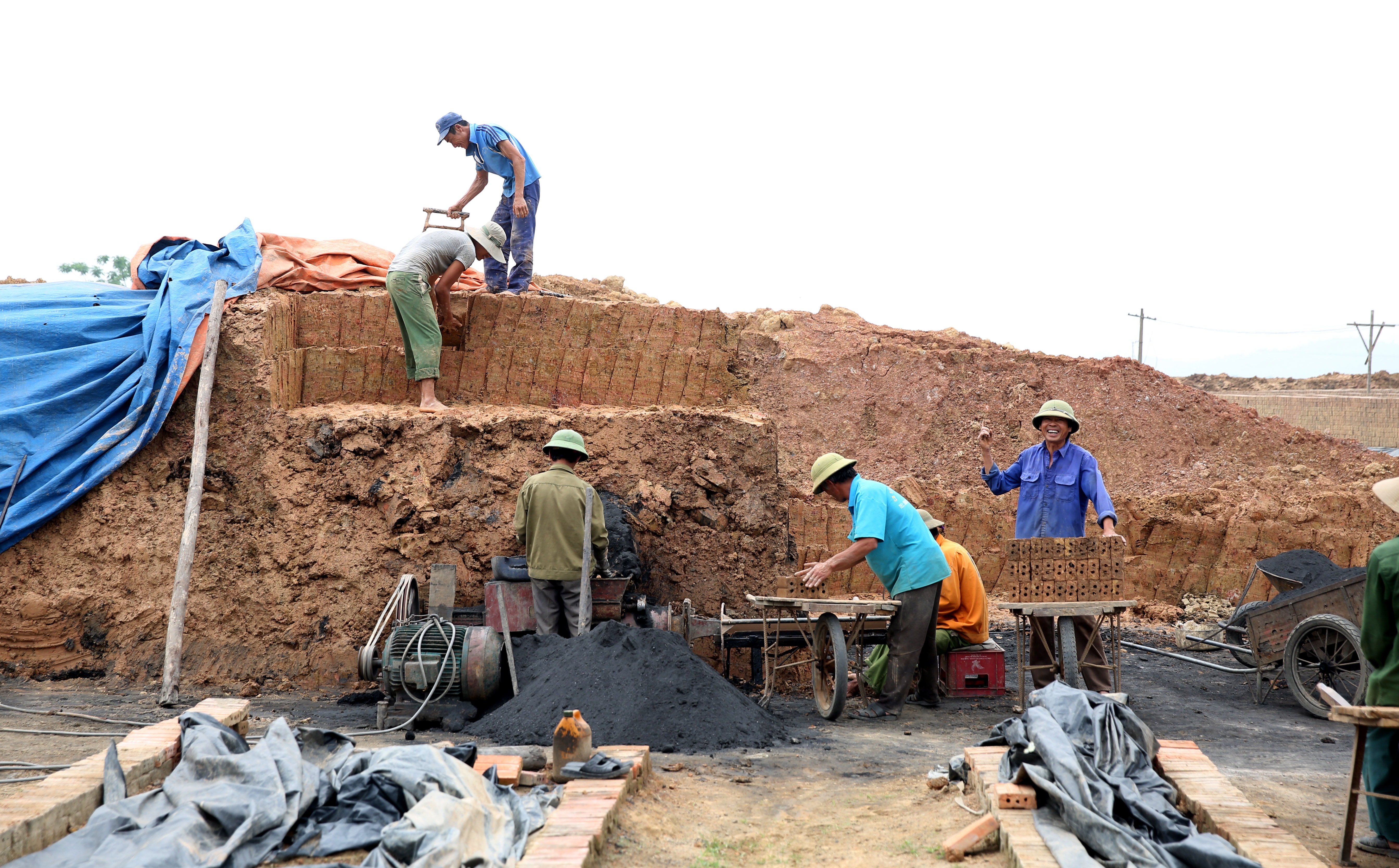 Thời điểm phóng viên có mặt tại lò gạch, có 7 người công nhân đang quây quanh chiếc máy để sản xuất ra những viên gạch mới. Cách đó không xa có 2 lò gạch, 1 chiếc đang đỏ lửa  để nung gạch và một còn lại đang chuẩn bị ‘đỏ lửa’.