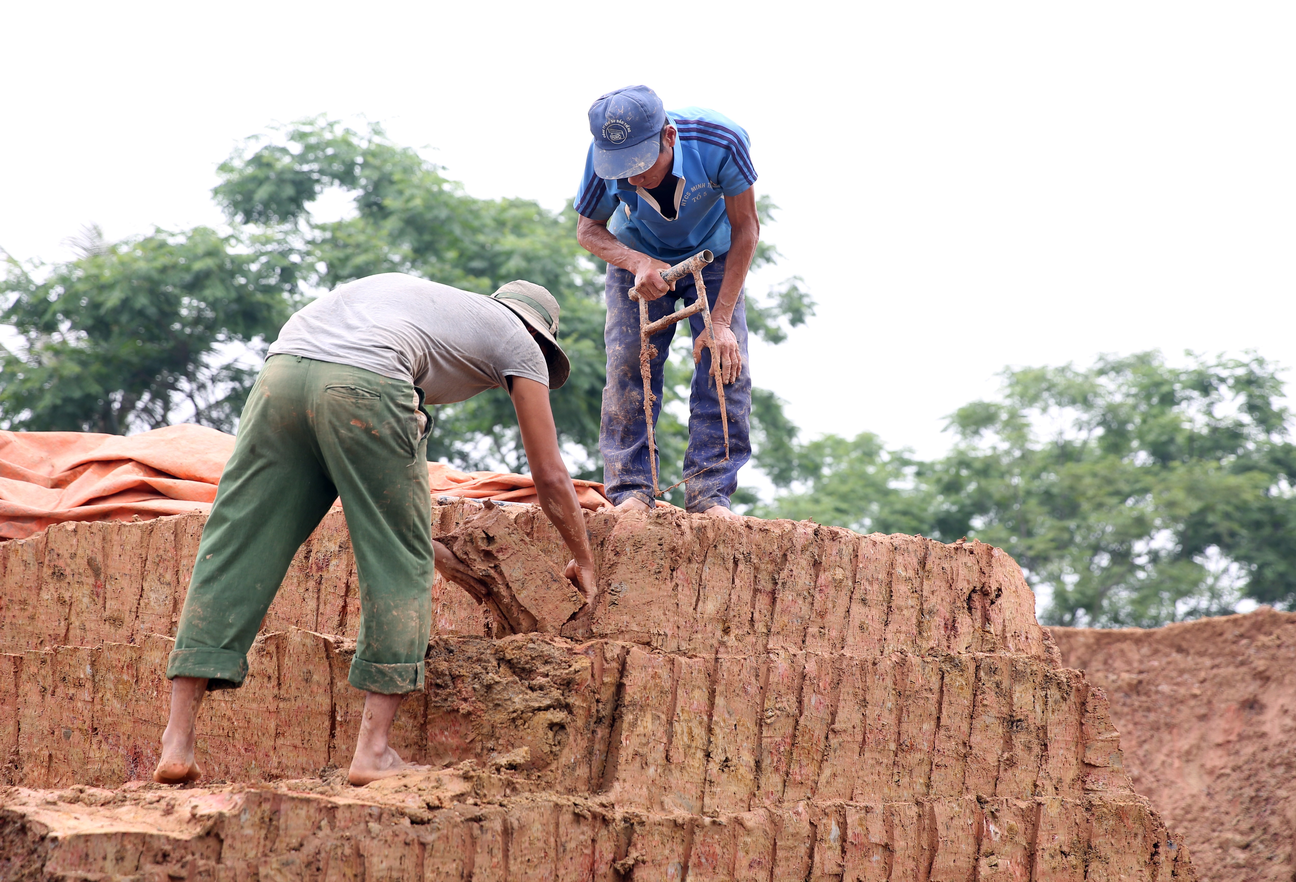 Tìm hiểu được biết, lò gạch đang hoạt động tại xóm Đồng Đại, xã Nghĩa Khánh, huyện Nghĩa Đàn đang do ông Phan Văn Dũng, trú cùng xã đứng chủ. Trong ảnh: Hai người làm nhiệm vụ cắt đất hối hả bỏ vào hốc máy.