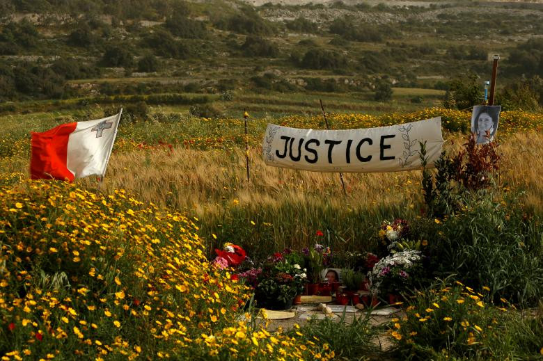 Tấm biểu ngữ đòi công lý gần bức ảnh chụp nhà báo chống tham nhũng bị sát hại Daphne Caruana Galizia tại địa điểm đặt bom, trong bối cảnh người Malta sắp tưởng niệm 6 tháng ngày nữ ký giả bị giết hại tại Bidnija, Malta hôm 15/4.