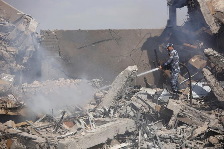 Cứu hỏa Syria trong đống đổ nát của Trung tâm nghiên cứu khoa học tại Damascus, Syria hôm 14/4.