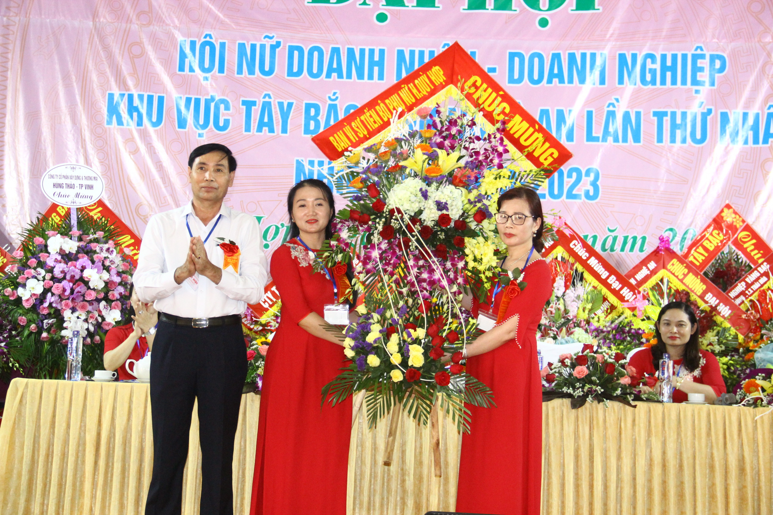 Lãnh đạo huyện Quỳ Hợp tặng hoa chúc mừng Chi hội nữ doanh nhân - doanh nghiệp khu vực Tây Bắc. Ảnh Hoàng Vĩnh.