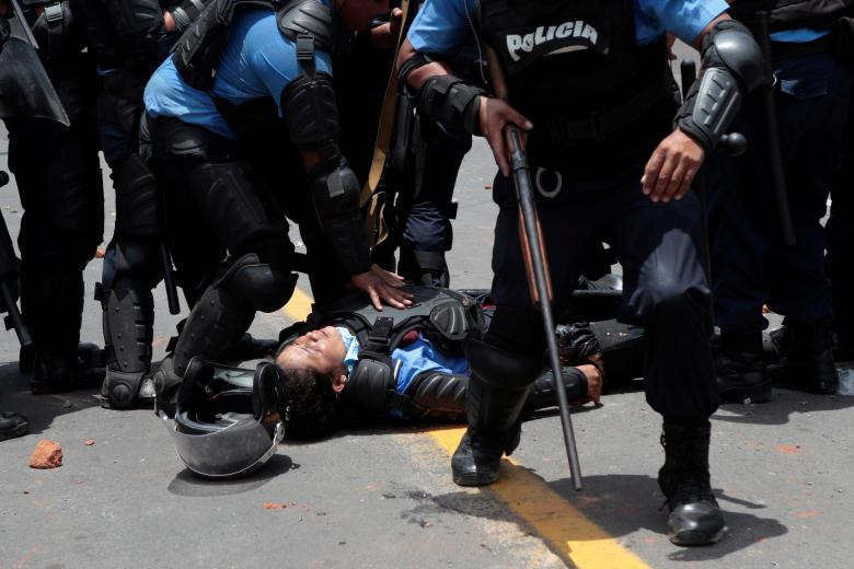 Một cảnh sát chống bạo động ngã xuống khi bị thương trong các cuộc đụng độ với sinh viên đại học biểu tình phản đối một cải cách gây tranh cãi đối với các kế hoạch lương hưu của Viện an sinh xã hội Nicaragua (INSS) tại Managua, Nicaragua hôm 20/4.