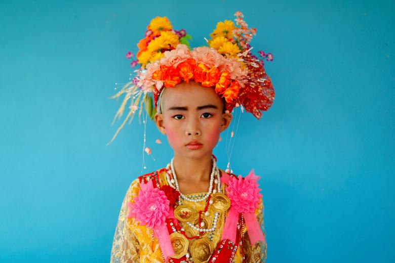 Danusorn Sdisaithaworn, 10 tuổi, chụp ảnh chân dung trong buổi lễ Poy Sang Long được tổ chức hàng năm, một nghi lễ truyền thống dành cho các bé trai bắt đầu trở thành người nhà Phật, khi cậu tới thăm nhà họ hàng ở ngoại ô Mae Hong Son, Thái Lan hôm 24/4.