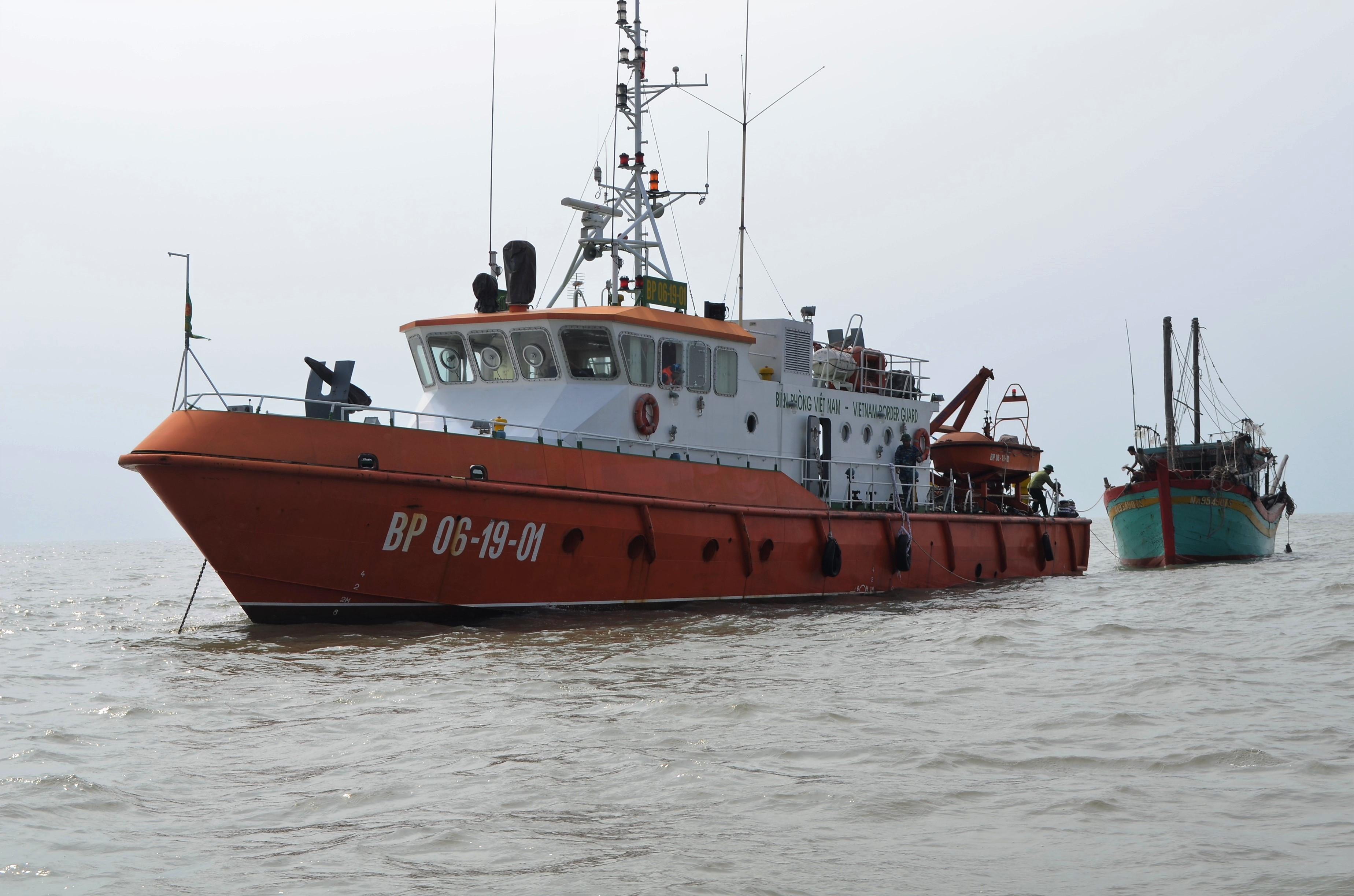 Tàu cứu nạn của BĐBP Nghệ An lai dắt tàu của ngư dân bị nạn trên biển về bờ an toàn. Ảnh: Phương Linh
