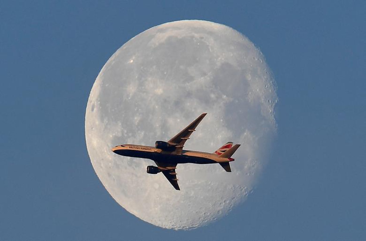 Một máy bay của hãng British Airways bay trước mặt trăng, thủ đô London (Anh). Ảnh: Reuters