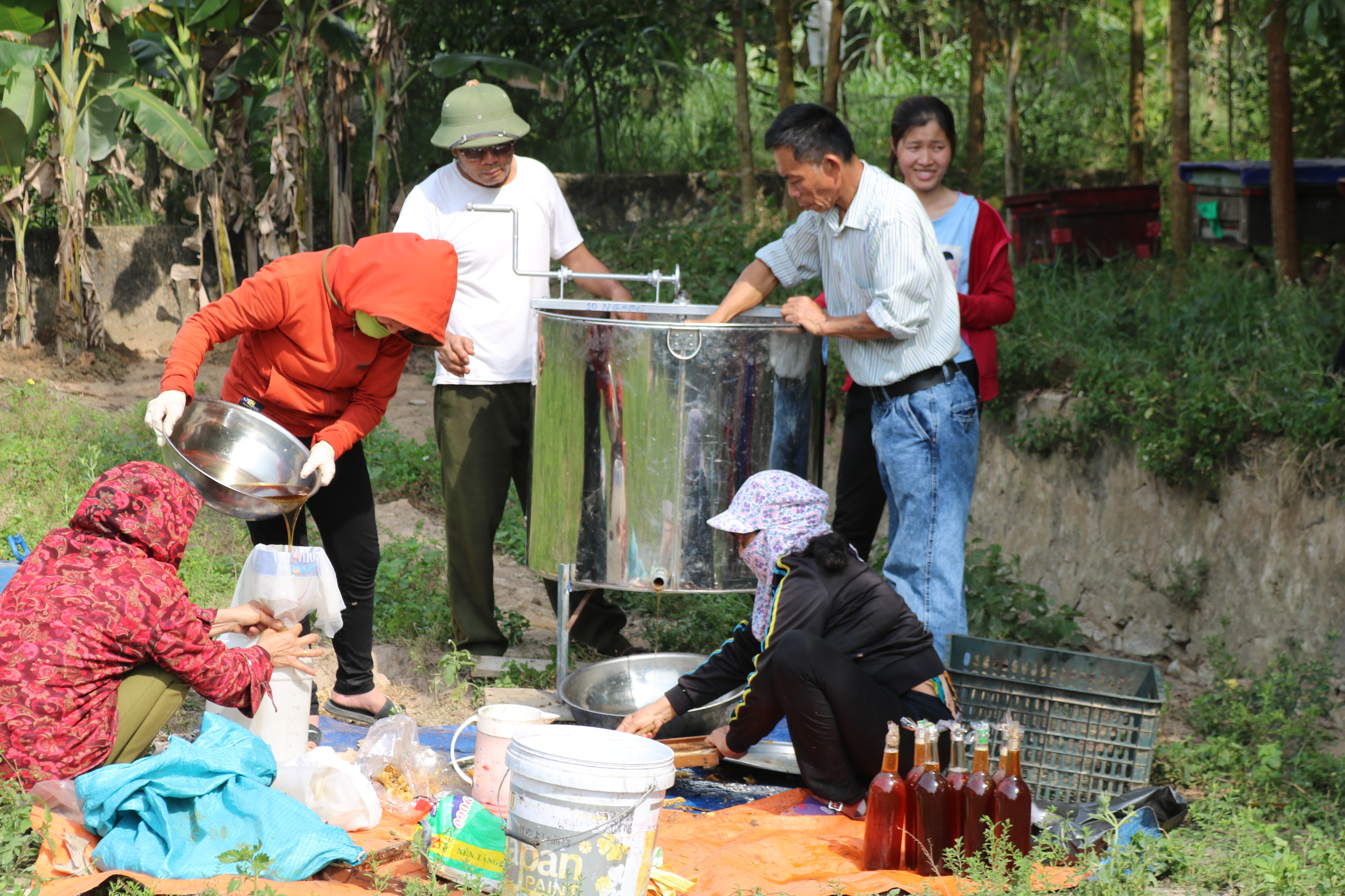 Trong ngày quay mật, một hộ nuôi ong huy động từ 4 - 5 người để đảm bảo làm nhanh, gọn các công đoạn. Mật ong hoàn toàn bằng tự nhiên nên các hộ gia đình quay đến đâu được người dân xung quanh khu vực đến mua ngay đến đó, một phần khác được các tư thương nhập để đem đi bán lẻ. Ảnh: Hồng Diện