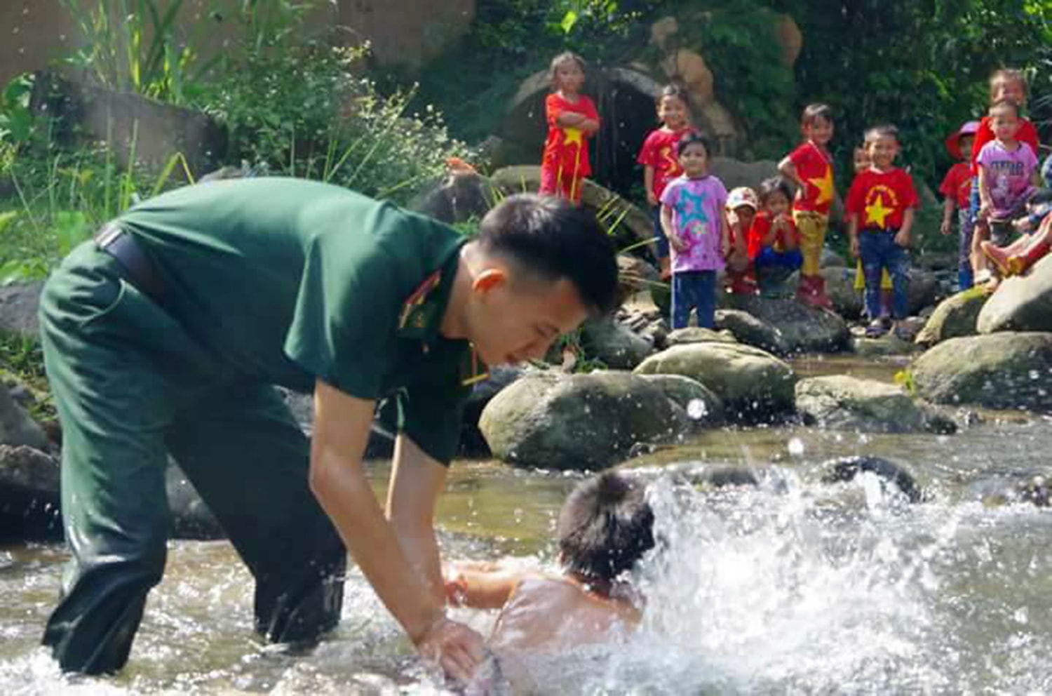 Chiến sỹ Đồn Biên phòng Tam Hợp đang dạy bơi cho các cháu. Ảnh: TP