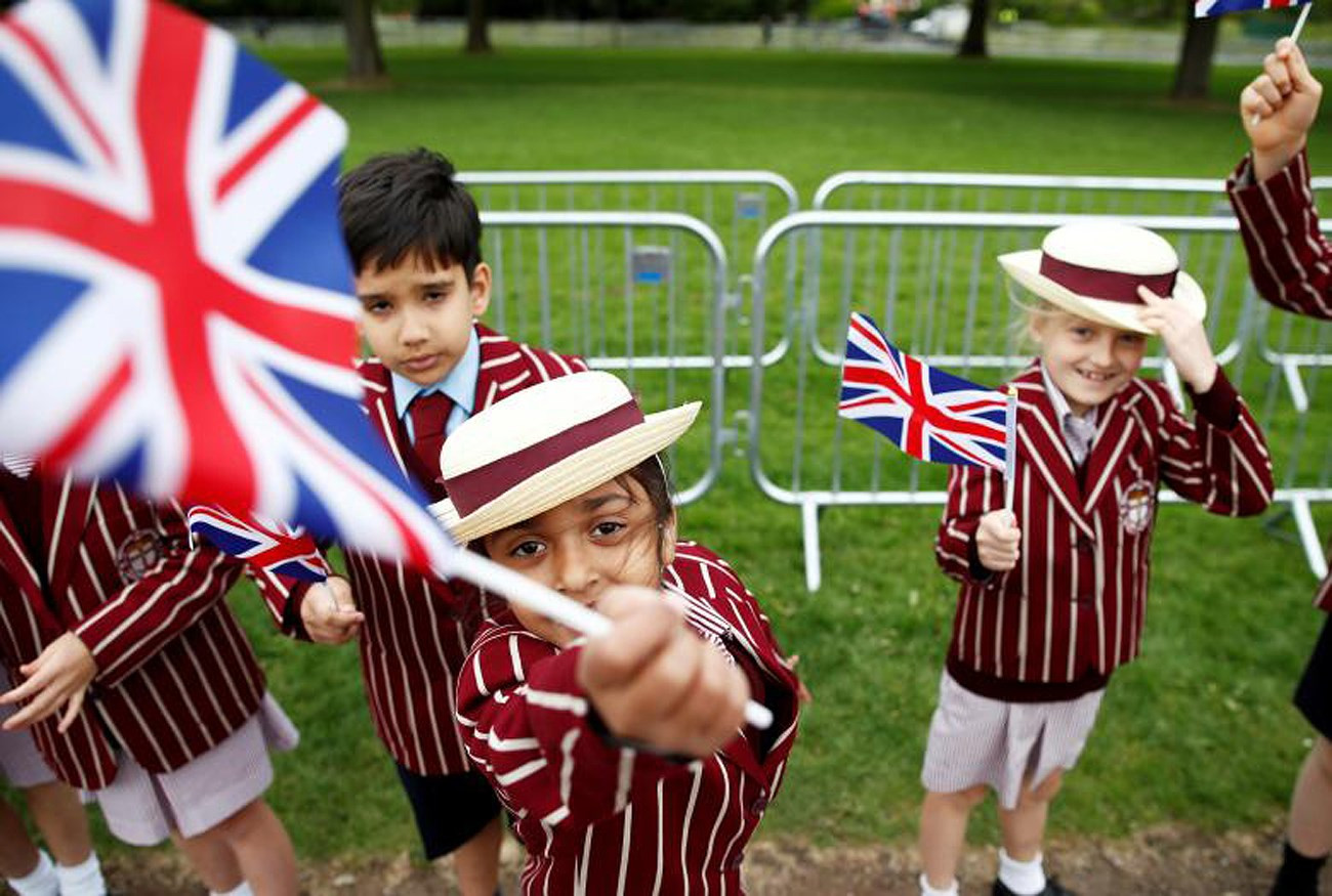 Các em vẫy cờ bên ngoài lâu đài Windsor (Anh), nơi sẽ diễn ra hôn lễ của Hoàng tử Harry và nữ diễn viên người Mỹ Meghan Markle. Ảnh: Reuters