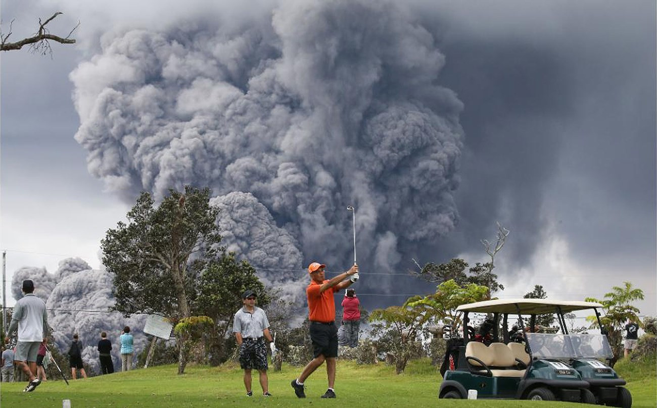 Một người đàn ông chơi golf ở gần khu vực phun tro bụi từ núi lửa Kilauea trên Đảo Lớn của Hawaii. Ảnh: Getty