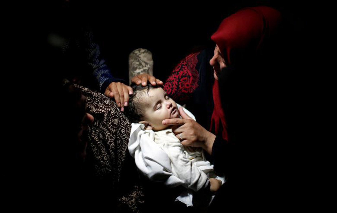 Một đứa trẻ Palestine thiệt mạng sau khi hít phải khí cay trong một cuộc biểu tình tại biên giới Israel-Gaza. Ảnh: Reuters