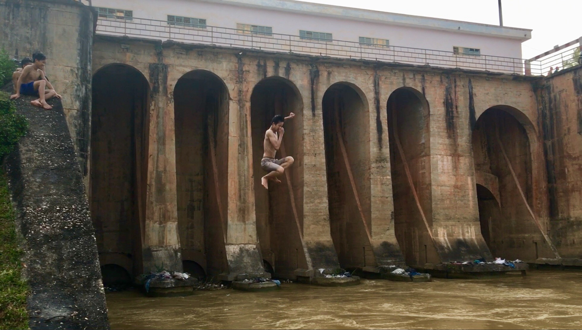Cú nhảy từ độ cao trên 15 m, nước mặt sông rất quẩn dễ bị cuốn vào các cửa cống. Ảnh: Lê Ngọc Phương