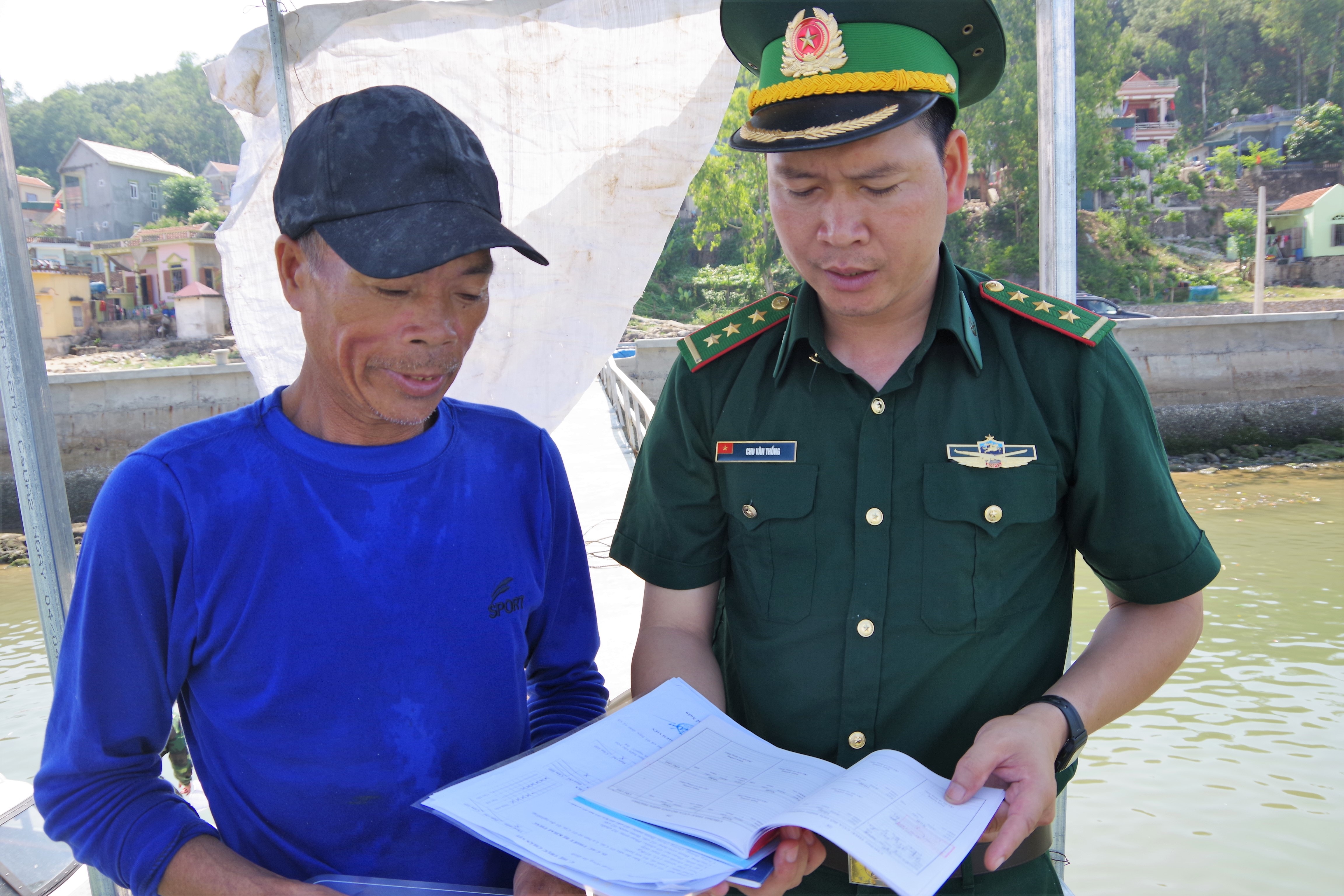 Cán bộ Trạm kiểm soát Lạch Cờn, Đồn Biên phòng Quỳnh Phương kiểm tra giấy tờ, phương tiện của ngư dân ra khơi khai thác thủy sản. Ảnh: Hùng Phong