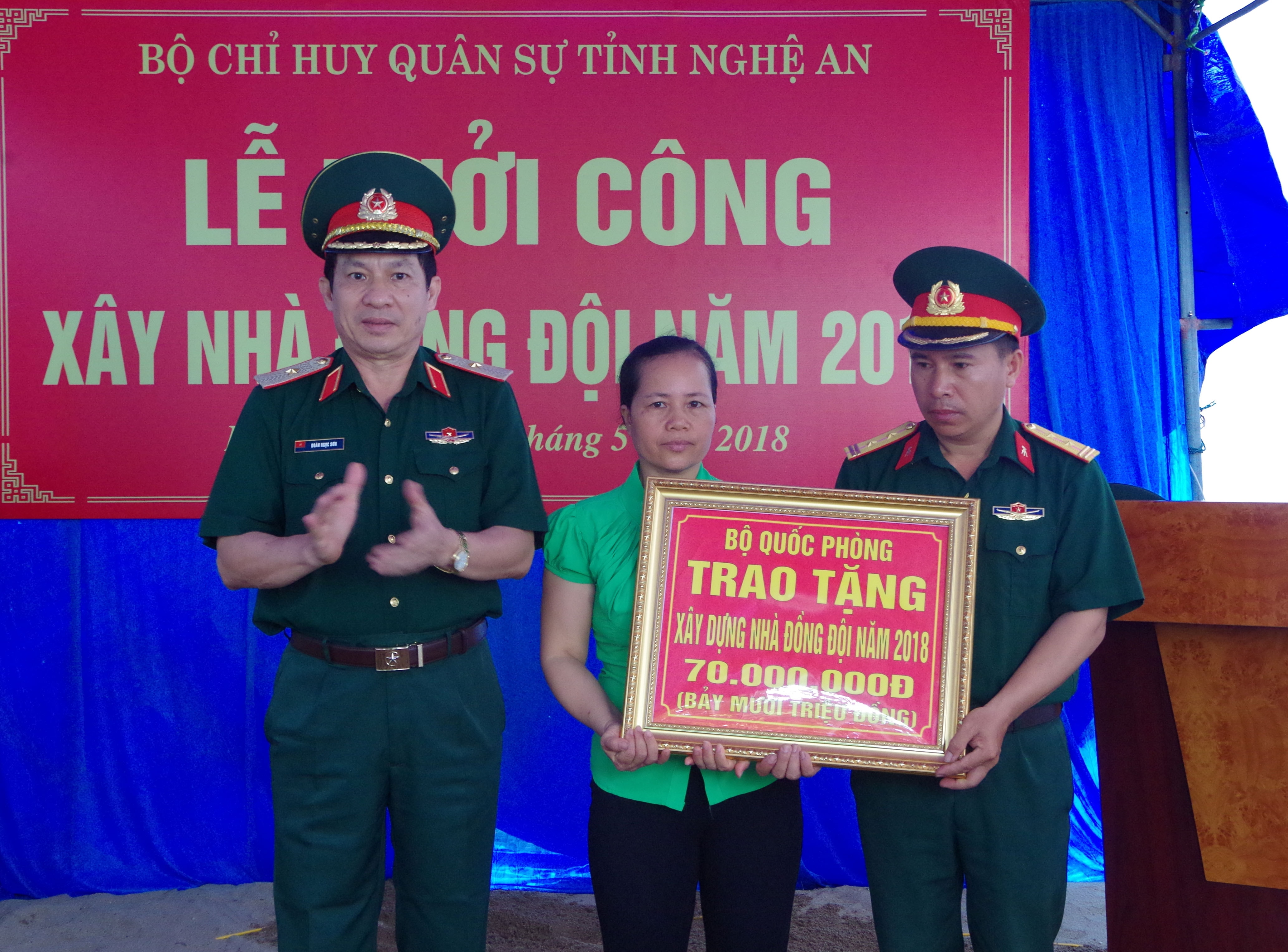 Đồng chí Thiếu tướng Doãn Ngọc Sơn - Phó Chủ nhiệm Chính trị Quân khu 4 trao tiền hỗ trợ làm nhà cho gia đình đồng chí Trung tá Quân nhân chuyên nghiệp Ngô Song Hùng - Thủ kho K70, Phòng Kỹ thuật Bộ CHQS tỉnh. Ảnh: Trọng Kiên