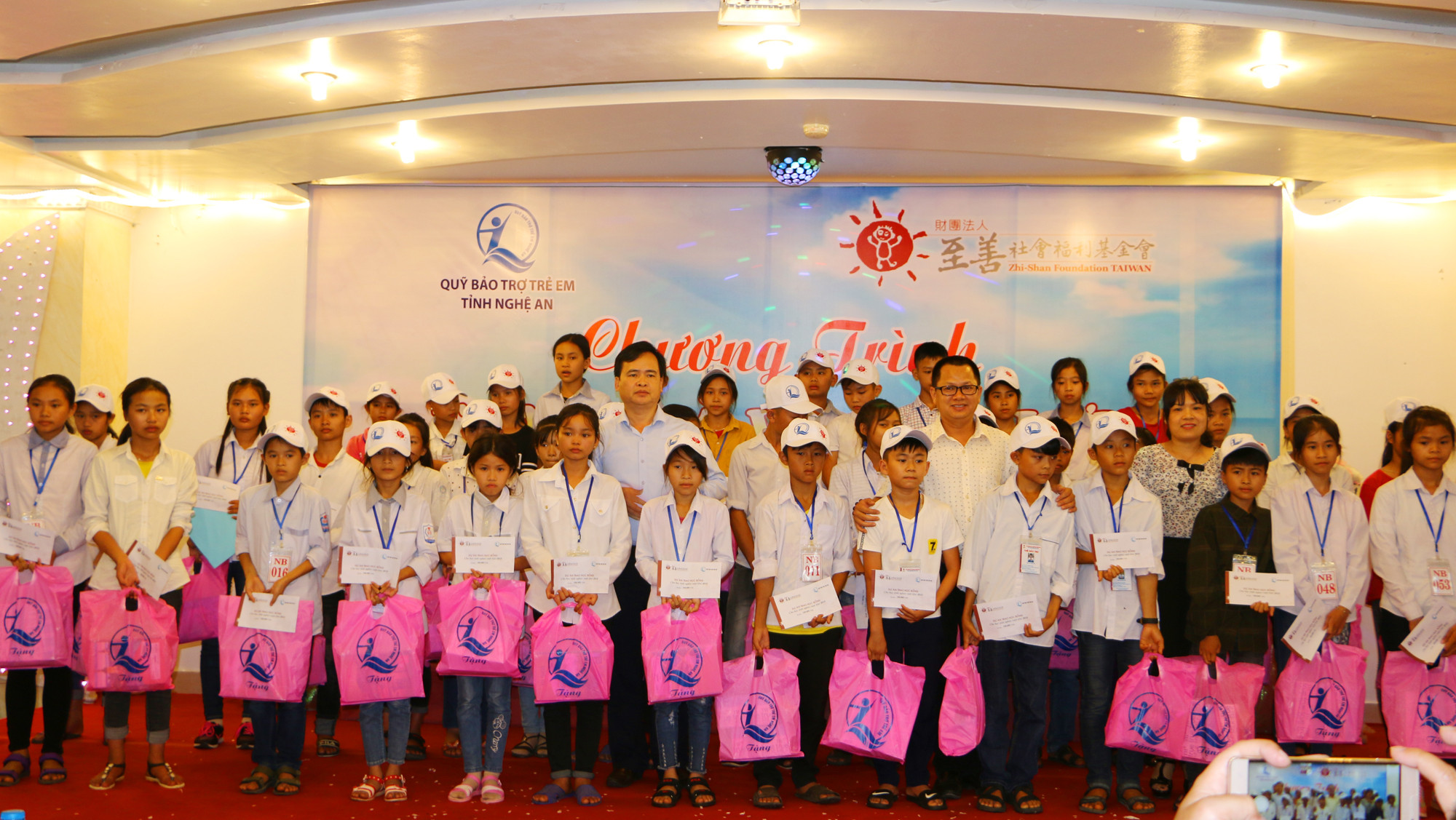 Đại diện Quỹ Bảo trợ trẻ em và Nhà tài trợ trao quà cho 40 học sinh tiên tiến có hoàn cảnh khó khăn. Ảnh: Nguyễn Hải 