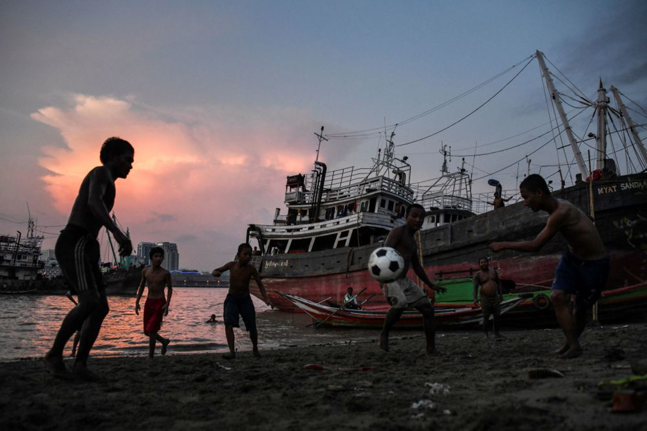 Nhóm thanh niên chơi bóng đá trên bờ sông Yangon ở thủ đô Yangon, Myanmar. Ảnh: AFP