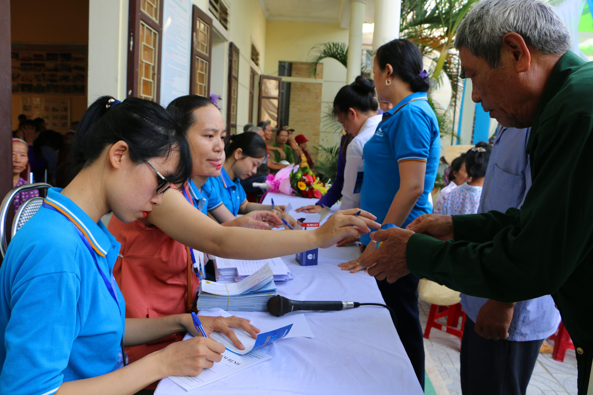 Cán bộ Bảo Việt Nhân thọ Bắc Nghệ An hướng dẫn thủ tục cho người dân đến khám bệnh. Ảnh: Nguyễn Hải
